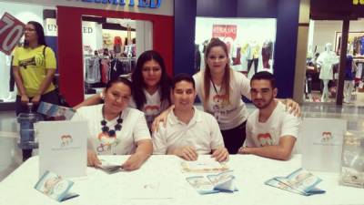 Karen Madrid y Jordan Lagos con otros voluntarios informan sobre la fundación.