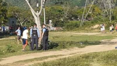 El cadáver está en la orilla de una calle de tierra.