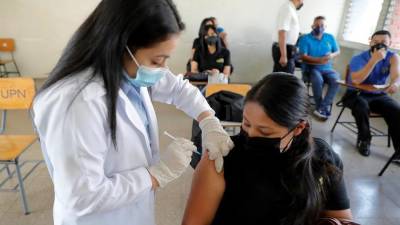 Una trabajadora de la salud vacuna a una mujer contra el coronavirus en Tegucigalpa.