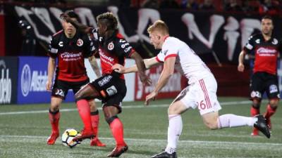 El jugador de Xolos de México Miller Bolaños (c) disputa el balón con Tim Parker (d) del New York Red Bulls de Estados Unidos.