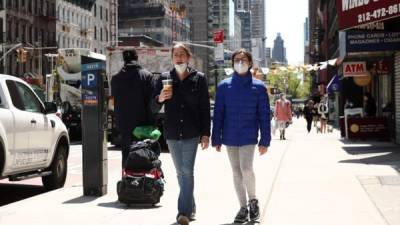 La gente camina con máscaras protectoras durante la pandemia de coronavirus en la ciudad de Nueva York. Foto AFP