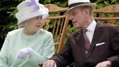 En esta foto tomada el 17 de julio de 2002, la reina Isabel II de Gran Bretaña y el príncipe Felipe de Gran Bretaña, conversan sentados durante una actuación musical en los jardines de la abadía, Bury St Edmunds, durante su Jubileo de Oro. Foto AFP