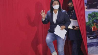 La candidata presidencial Keiko Fujimori saluda con la mano cuando llega a una conferencia de prensa en la sede de su partido en Lima. Foto AFP