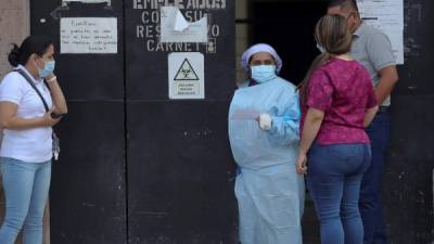 Una enfermera brinda información a personas que tienen interno a su familiar en el Hospital San Felipe, hoy en Tegucigalpa (Honduras).