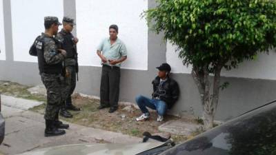 Se desconoce la identificación de los detenidos, uno de ellos es el taxista (camisa verde). Foto: Radio América.