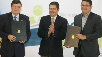 Senén Villanueva, representante de las universidades privadas; el presidente Juan Orlando Hernández y el ministro Marlon Escoto en la firma del convenio.