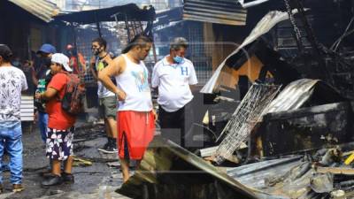 Vendedores mirando cómo lo perdieron todo a raíz del incendio de grandes proporciones.