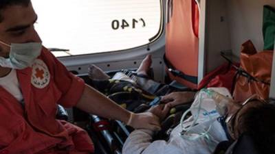 Uno de los heridos es atentido por un paramédico de la Cruz Roja.