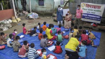 Los niños de un vecindario de bajos ingresos asisten a una clase en una escuela al aire libre. Foto AFP