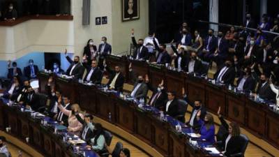 Diputados pertenecientes al partido gobernante Nuevas Ideas votan para destituir a un grupo de jueces durante la primera sesión plenaria de la Asamblea Legislativa. Foto AFP