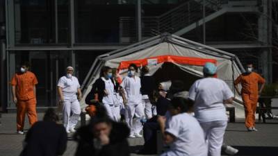 Los trabajadores de la salud se encuentran frente al centro de convenciones y exposiciones Ifema en Madrid, donde se encuentra un hospital temporal para pacientes con COVID-19. Foto AFP