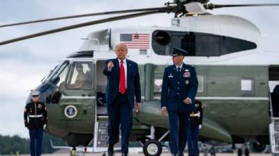 Donald Trump saluda tras desembarcar del Marine One para abordar el Air Force One rumbo a Miami.