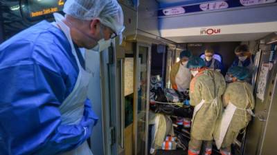 El personal médico transporta a un paciente infectado con el COVID-19 a bordo de un tren de alta velocidad TGV medicalizado en la estación en Estrasburgo, este de Francia, el 3 de abril de 2020, antes de su evacuación, junto con otros 23 pacientes hacia hospitales del sur de Francia en Burdeos, Francia.