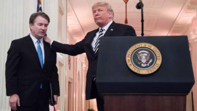 El presidente de los Estados Unidos, Donald Trump, le da una palmada al juez asociado de la Corte Suprema de los EEUU, Brett Kavanaugh durante un juramento ceremonial en la Casa Blanca en Washington. Foto AFP