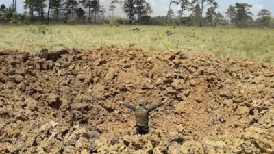 Un militar camina en medio de la pista destruida.