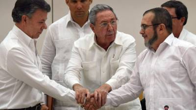 El presidente colombiano Juan Manuel Santos, el mandatario cubano Raúl Castro y el jefe guerrillero 'Timochenko' en uno de los encuentros por el proceso de paz en La Habana. AFP