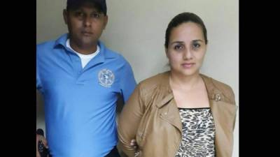 La detenida cuando era custodiada por un agente de la Policía hondureña.