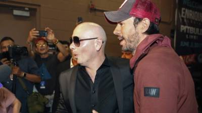 Los cantantes Enrique Iglesias (d) y Pitbull (c), luego de un concierto de su gira por Estados Unidos. EFE/Archivo