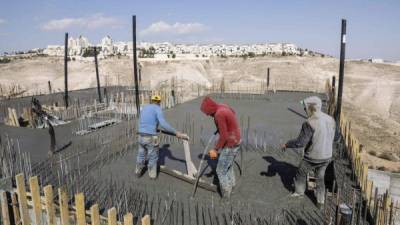 Trabajadores de la construcción colocan una fundición en el asentamiento israelí de Maale Adumim.