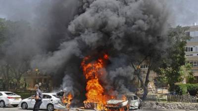 Los vehículos se muestran en llamas después de que un cohete lanzado desde la Franja de Gaza, controlado por el movimiento palestino Hamas. Foto AFP