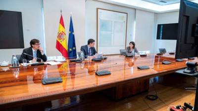 El presidente del Gobierno, Pedro Sánchez (c), el ministro de Sanidad, Salvador Illa, y María José Sierra, del Centro de Coordinación de Alertas y Emergencias Sanitarias, durante la reunión del Comité Científico Técnico que sigue la crisis del coronavirus, hoy sábado en el Palacio de La Moncloa, en Madrid.