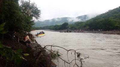 Pobladores cruzan el río en lancha.