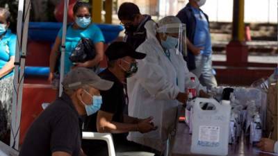 Personas son atendidas por una brigada médica para detectar casos de la Covid-19 hoy, en el municipio de Valle de Ángeles (Honduras).