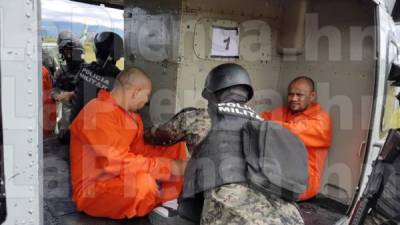 Miembros de la Policía Militar acomodan a los criminales en los helicópteros de la Fuerza Aérea Hondureña (FAH).