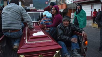 Familiares de una de las dieciocho personas asesinadas acompañan a un ataúd cuando es transportado en un camión después de un accidente de carretera en el municipio de Nahuala, departamento de Solola, a unos 160 kilómetros al oeste de la Ciudad de Guatemala. Foto AFP.