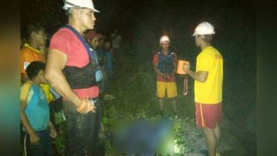 Elementos del Cuerpo de Bomberos al momento de hacer el rescate del cadáver del menor de cinco años en Comayagua.
