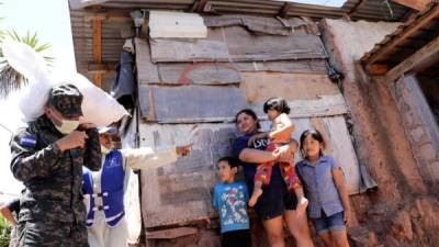 El personal de las Fuerzas Armadas es el encargado de distribuir las raciones de alimentos. Fotos: facebook Arnaldo Bueso y AFP.