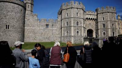 La gente se reúne frente a la entrada del Castillo de Windsor en Windsor, al oeste de Londres, antes del funeral del príncipe Felipe. Foto AFP