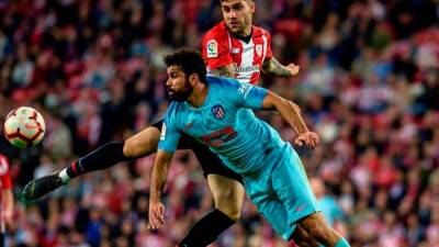 El delantero hispano-brasileño del Atlético de Madrid, Diego Costa (d), intenta rematar ante el defensa del Athletic, Unai Nuñez, en el estadio de San Mamés, en Bilbao.