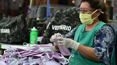 El personal de la Industria Militar de las Fuerzas Armadas de Honduras, realiza máscaras faciales para miembros del sector de la Salud que están en primera línea en la lucha contra el nuevo coronavirus. Foto AFP