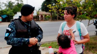 Una migrante hondureña acompañada de una niña llora después de que miembros de la policía retuvieran la caravana para devolver a decenas de migrantes haca la frontera con Honduras. EFE