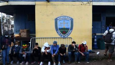 Los marineros hondureños que llegaron en las últimas horas al país esperan a que los miembros del Comité Permanente de Contingencia Hondureño (COPECO) hagan una prueba para detectar el nuevo coronavirus frente a una estación de policía en Tegucigalpa el 18 de marzo de 2020.