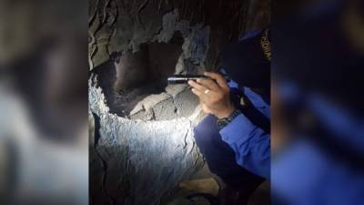 La Policía revisando el agujero dentro de la prisión en Roatán.
