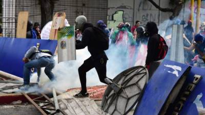 Los manifestantes de la oposición chocan con la policía durante una protesta en Caracas. AFP