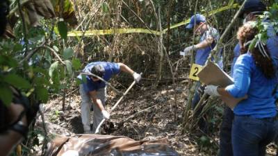 Personal forense excava en una de las fosas clandestinas para sacar uno de los cuerpos.