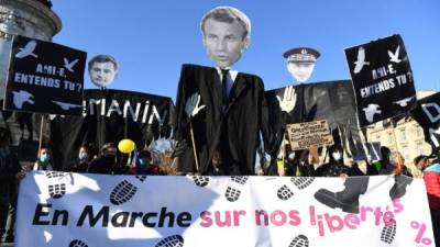 Los manifestantes sostienen efigies del presidente francés Emmanuel Macron, el ministro del Interior Gerald Darmanin y el prefecto de policía de París Didier Lallement en la Place de la Republique en París. Foto AFP