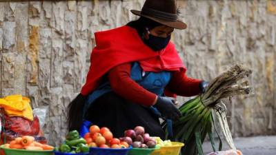 Una indígena ecuatoriana con mascarilla vende sus productos en una calle de la ciudad Riobamba de Ecuador.
