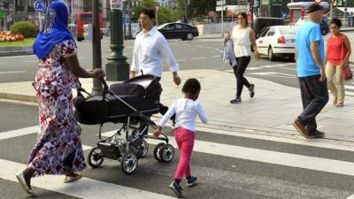 Varias personas cruzan un paso para peatones en Bilbao.