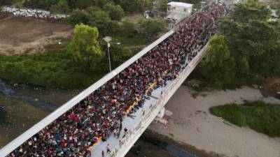 Los migrantes centroamericanos, en su mayoría hondureños, que viajan en caravana a los EE. UU., Permanecen en el puente internacional que conecta Tecum Uman, Guatemala, con Ciudad Hidalgo, México, el 20 de enero de 2020.