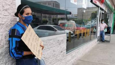 La residente hondureña Damaris Perdomo pide ayuda para comida ayer lunes, en una calle de Tegucigalpa (Honduras).