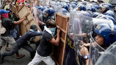 Policía antidisturbios y activistas se enfrentan durante una protesta contra Trump. EFE