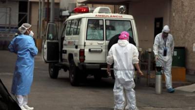 Personal médico vestidos con trajes de bioseguridad, trabajan en la atención de pacientes sospechosos de la covid-19 en el Hospital Escuela Universitario hoy en Tegucigalpa (Honduras).