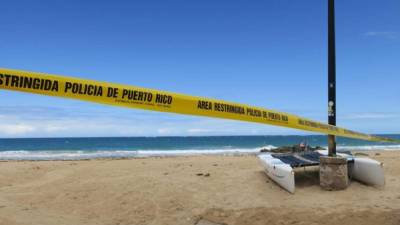 Vista de una cinta de aviso de 'Área restringida' puesta este jueves en la playa del sector de Condado en San Juan, Puerto Rico.