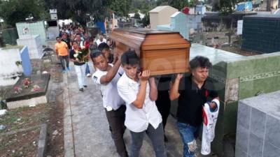 Familiares y amigos cargan el féretro que lleva los restos mortales de Cristopher Osmín Portillo.