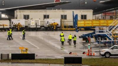 Los trabajadores caminan bajo la lluvia en las instalaciones de producción de aviones de Boeing. Foto AFP