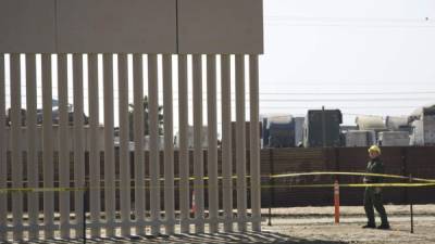 Un agente de la Patrulla Fronteriza observa las labores de construcción de uno de los prototipos del muro fronterizo. EFE/Archivo